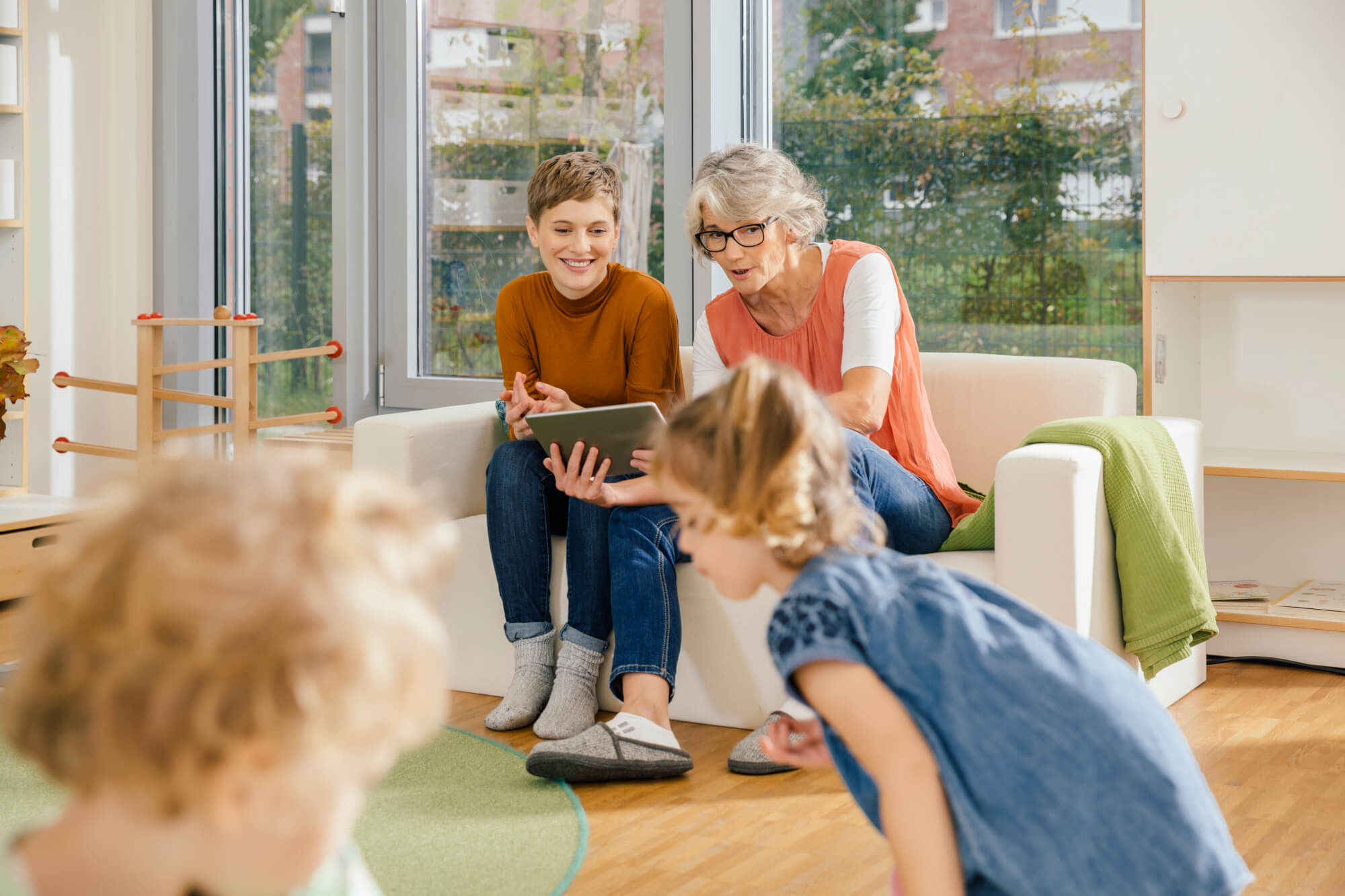 pre-school-teachers-with-tablet-looking-at-children-in-kindergarten.jpg