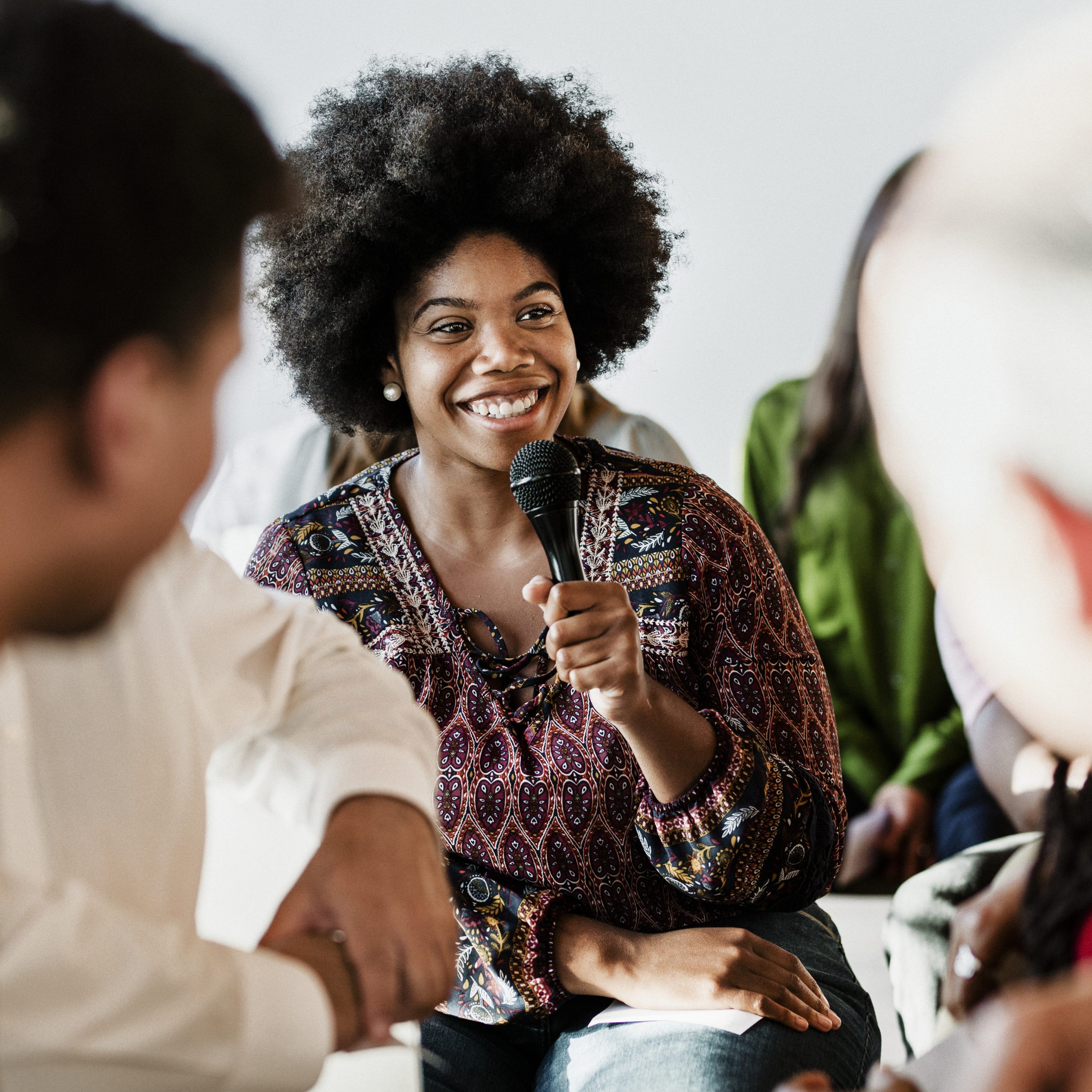 Cheerful woman speaking on a microphone in a workshop